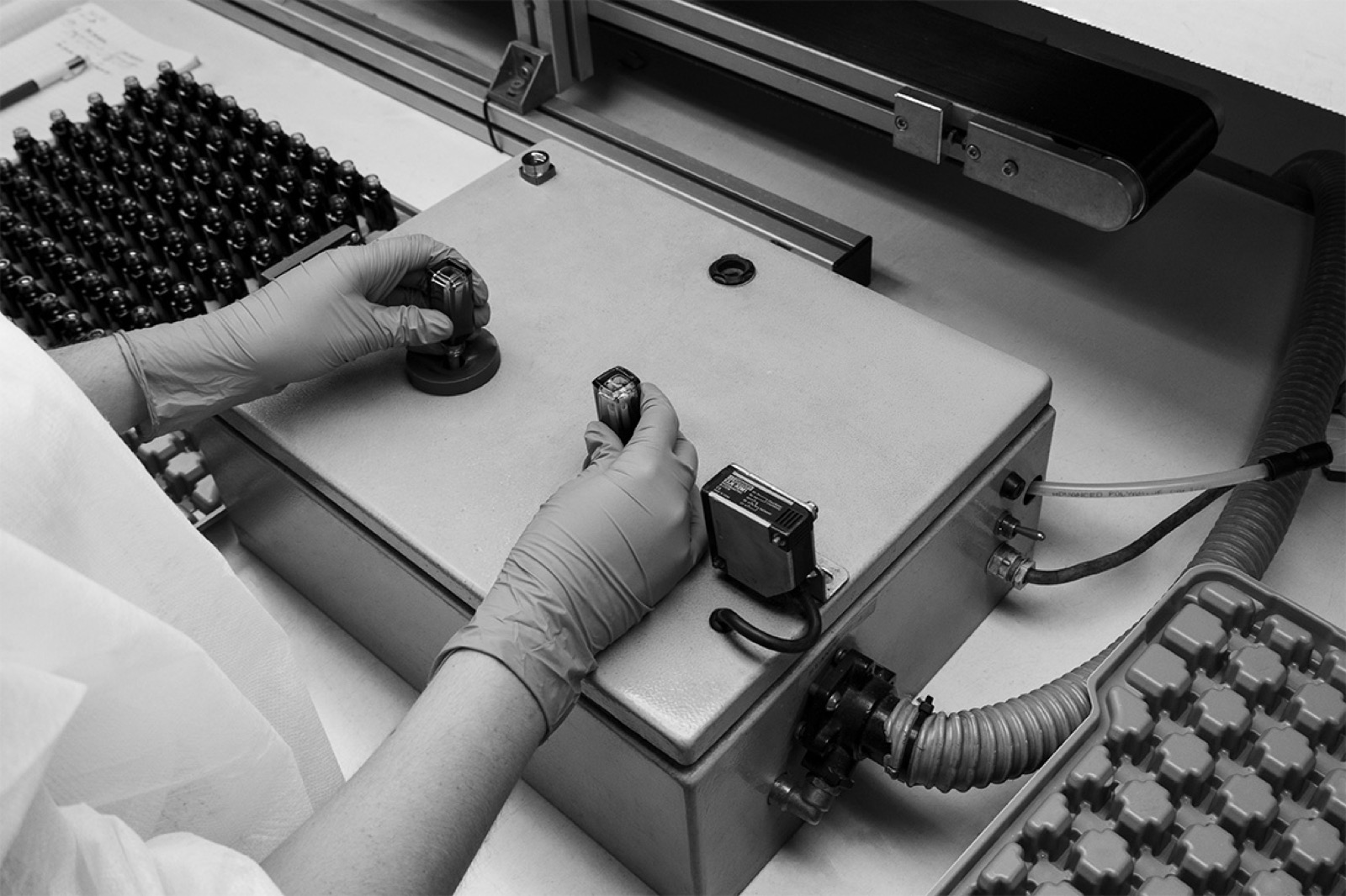 Gauge inspection at an equipped station, trays of bottles on either side