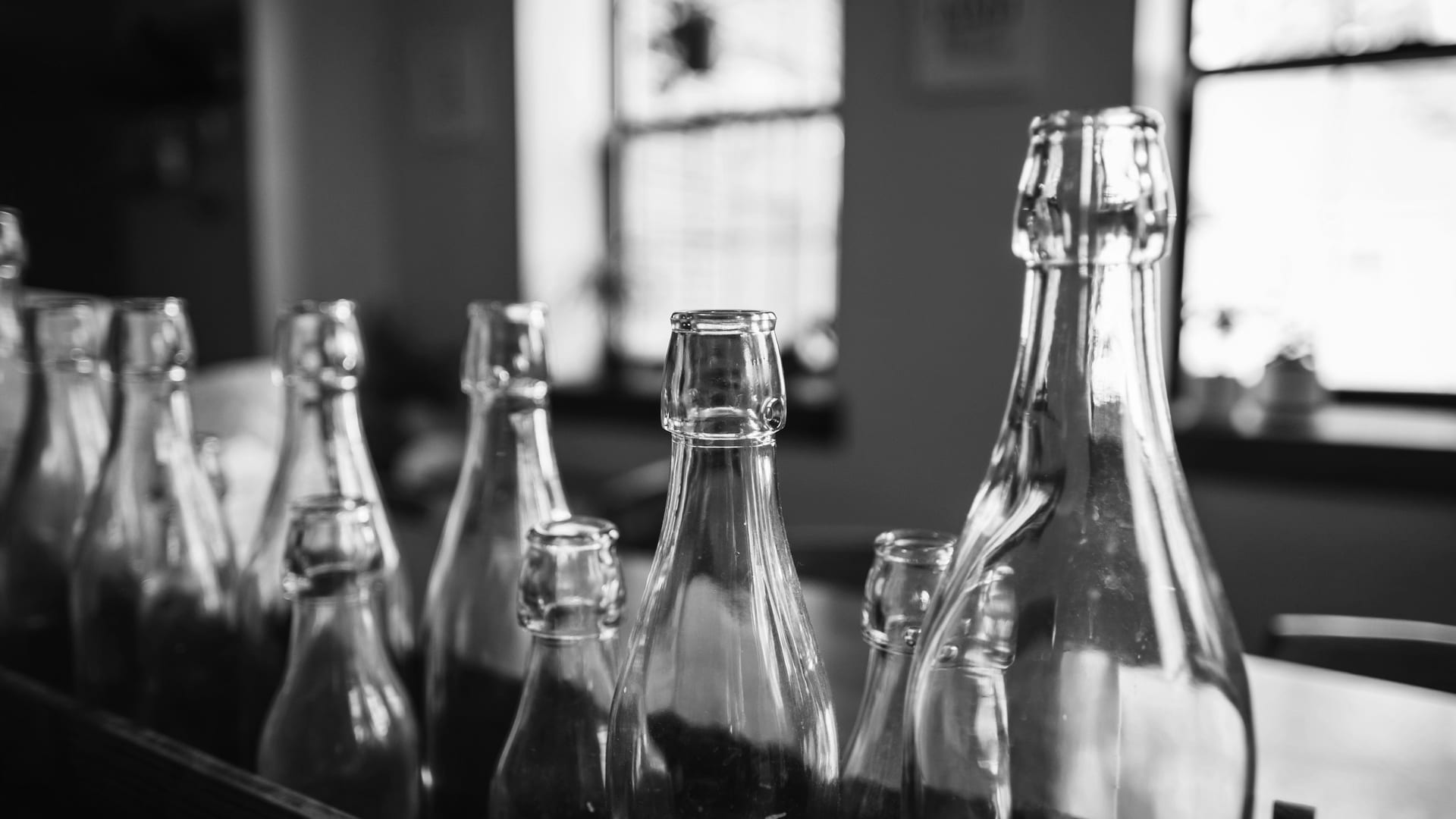 A row of glass bottles lined up against the light
