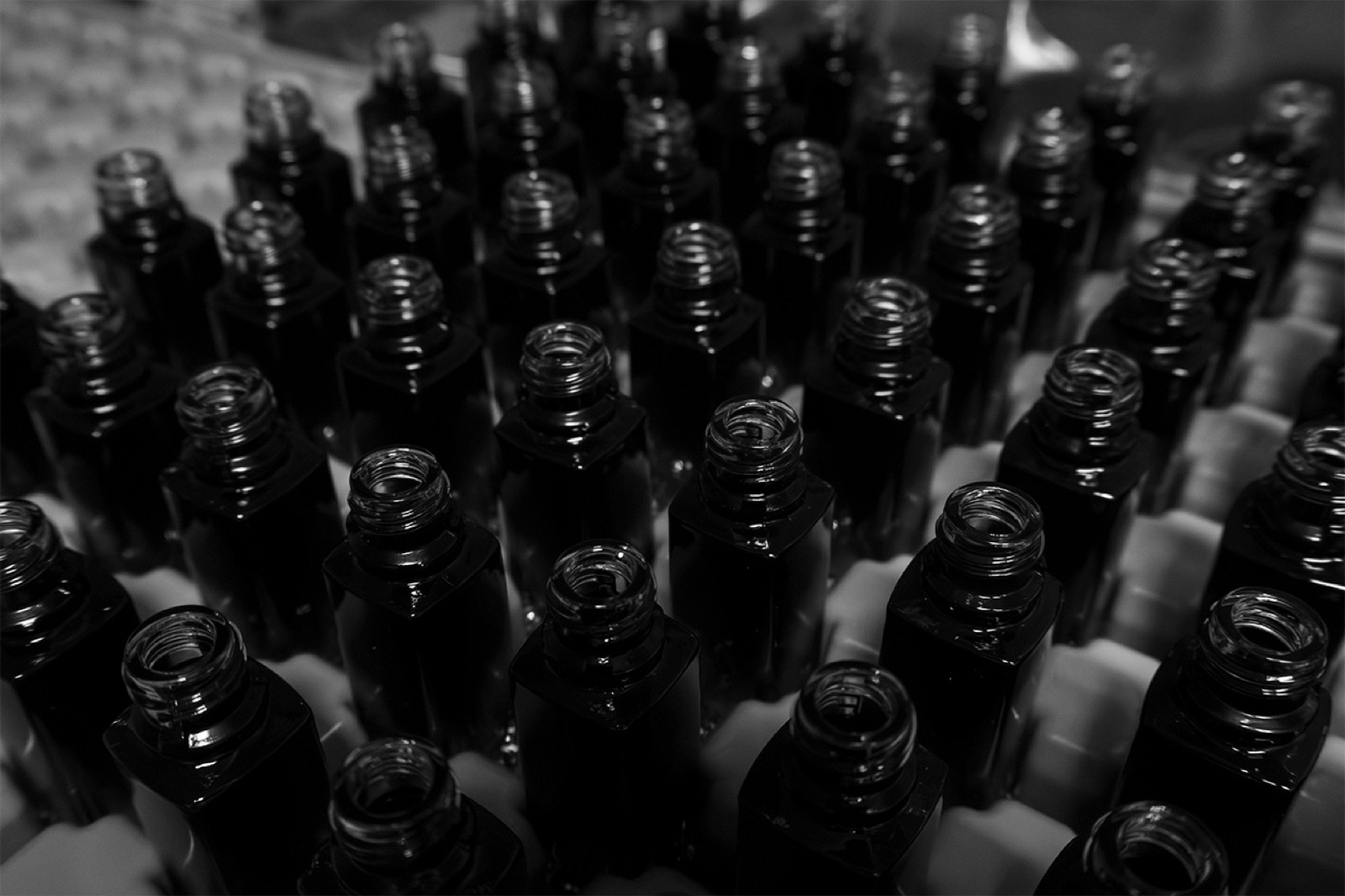 Unfinished glass bottles packed in a tray, seen from above