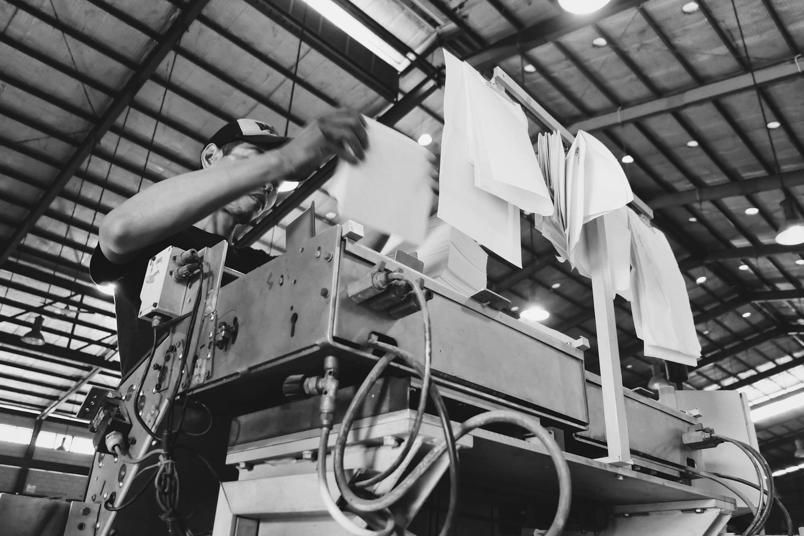 Operator running an industrial machine, log sheet in hand