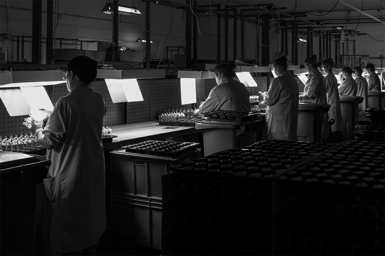 A row of lit inspection stations with teams at work